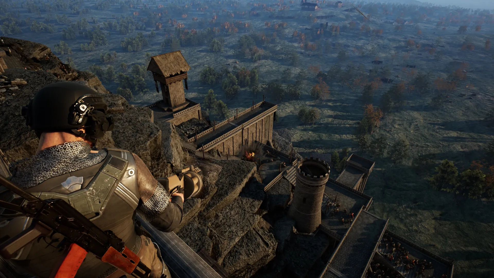 A soldier on a high rock ledge overlooks a castle and a river valley.
