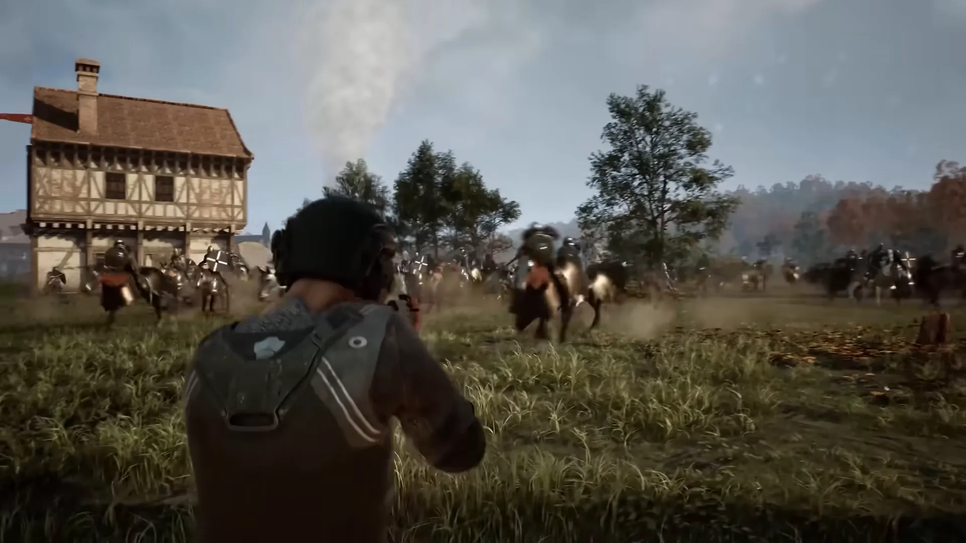 A soldier watches riders charge past a timber house.