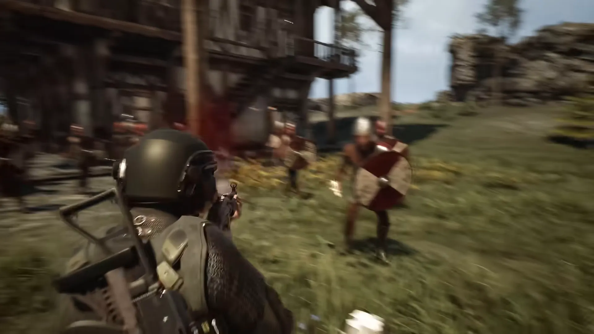 A helmeted soldier in an olive vest aims at an enemy holding a round shield in red and tan on a grassy slope; the picture is motion-blurred.